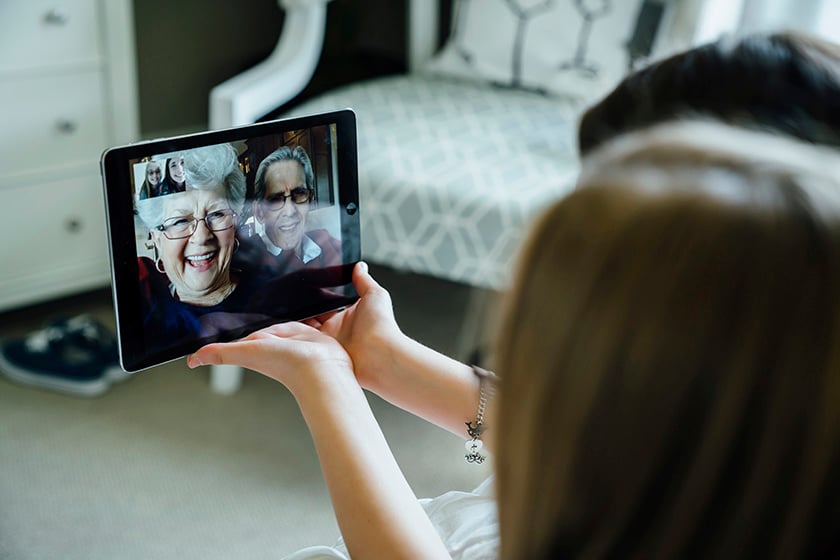 Woman talking to video on tablet of her grandparents